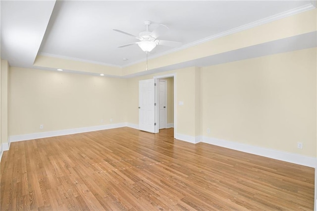 unfurnished room featuring crown molding, ceiling fan, a raised ceiling, and light wood-type flooring