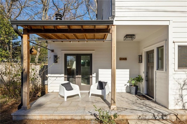 view of patio featuring french doors and fence