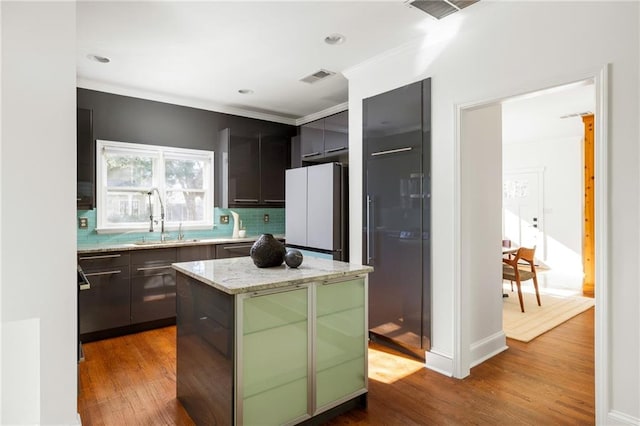 kitchen featuring dark wood-style floors, visible vents, a sink, and freestanding refrigerator