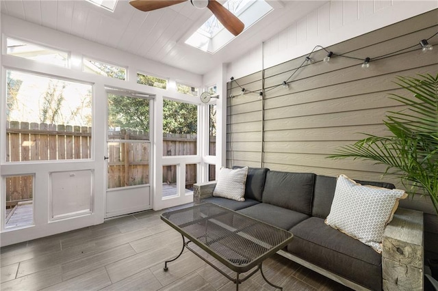 sunroom / solarium with ceiling fan and a skylight