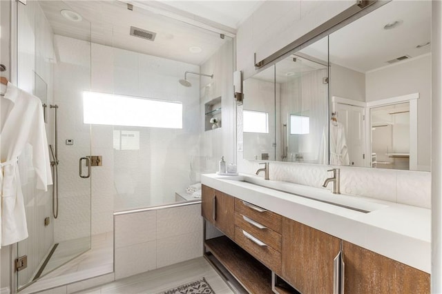 full bathroom featuring double vanity, a shower stall, and visible vents