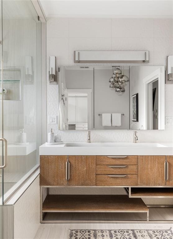 full bath with double vanity and a shower stall