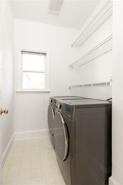 clothes washing area with laundry area, baseboards, and washing machine and clothes dryer