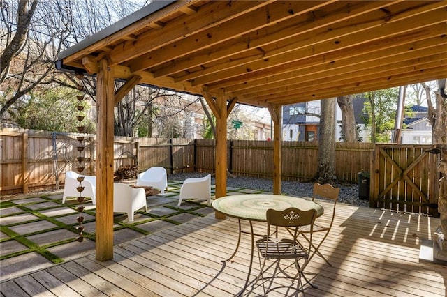 wooden terrace featuring a fenced backyard and a gate