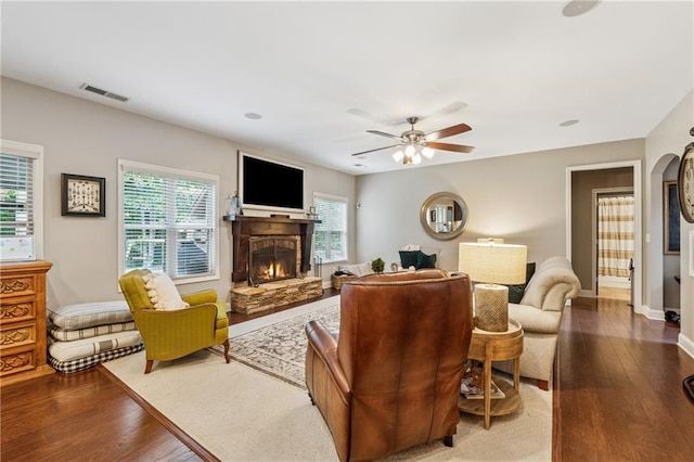 living room with a fireplace, wood finished floors, a ceiling fan, and baseboards
