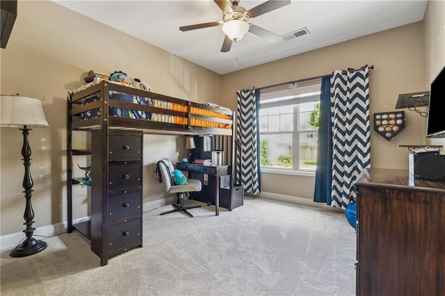 carpeted bedroom featuring an office area and baseboards