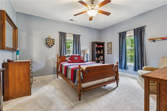 bedroom featuring light carpet, baseboards, and a ceiling fan