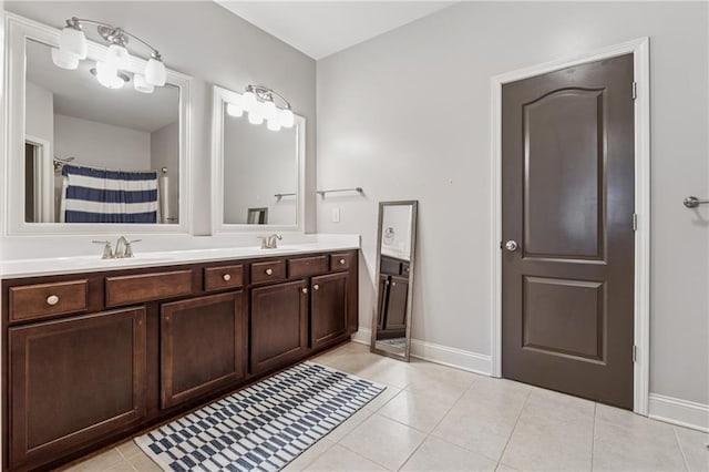 full bath featuring tile patterned floors, double vanity, baseboards, and a shower with curtain