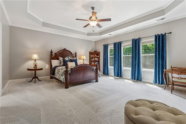 bedroom featuring a raised ceiling, crown molding, carpet floors, baseboards, and ceiling fan
