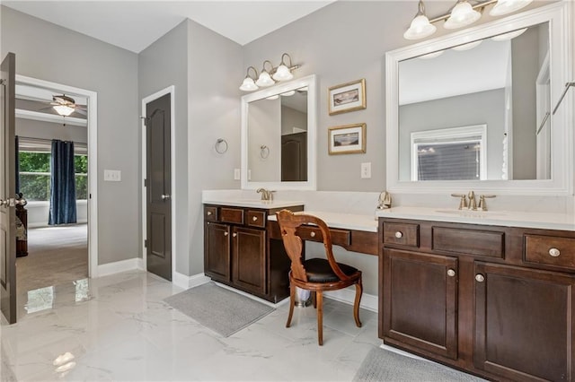 bathroom featuring marble finish floors, double vanity, baseboards, and a ceiling fan