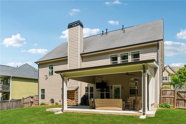 back of property with ceiling fan, a patio area, an outdoor living space, and a chimney