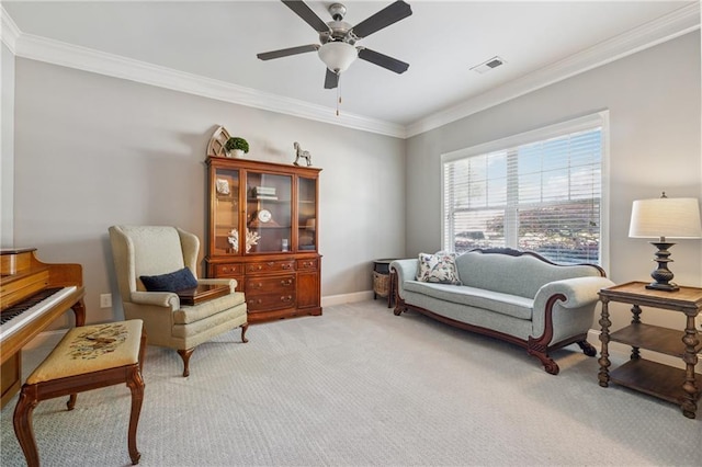sitting room with ceiling fan, crown molding, light colored carpet, and baseboards