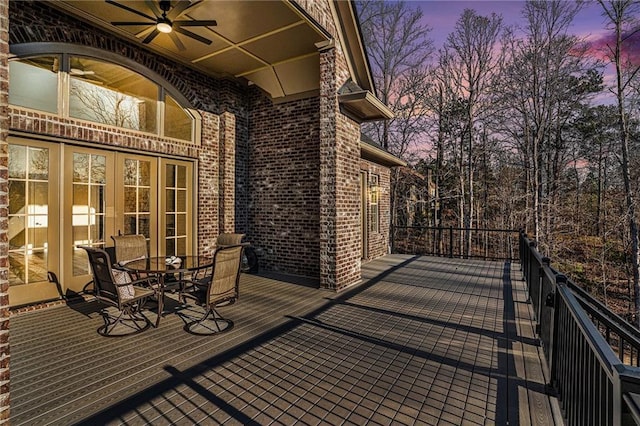 deck at dusk featuring ceiling fan