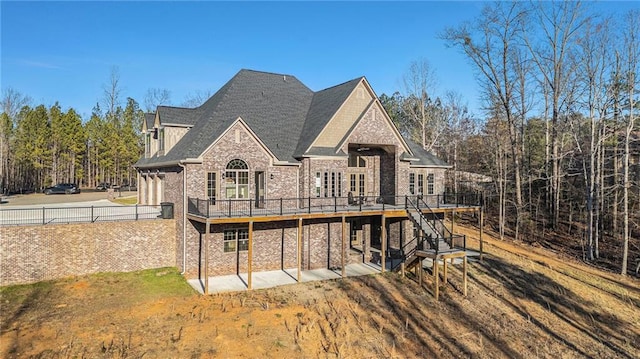 rear view of property with a deck and a lawn