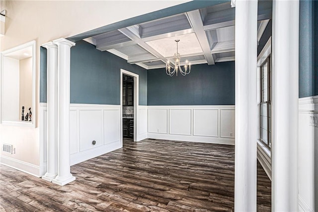 unfurnished dining area featuring beamed ceiling, dark wood-type flooring, an inviting chandelier, and coffered ceiling