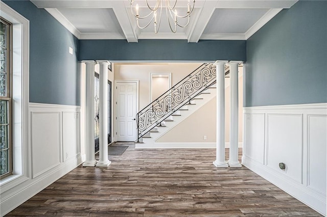 entrance foyer with hardwood / wood-style floors, coffered ceiling, ornate columns, a notable chandelier, and beam ceiling