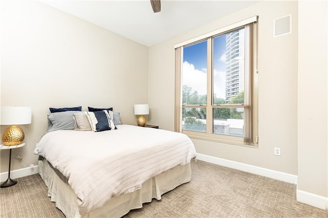 carpeted bedroom with ceiling fan and multiple windows