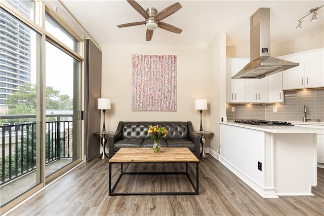 living room featuring ceiling fan, a healthy amount of sunlight, and wood-type flooring