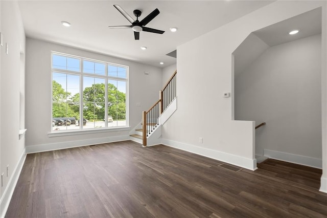 unfurnished living room featuring baseboards, ceiling fan, and dark wood finished floors