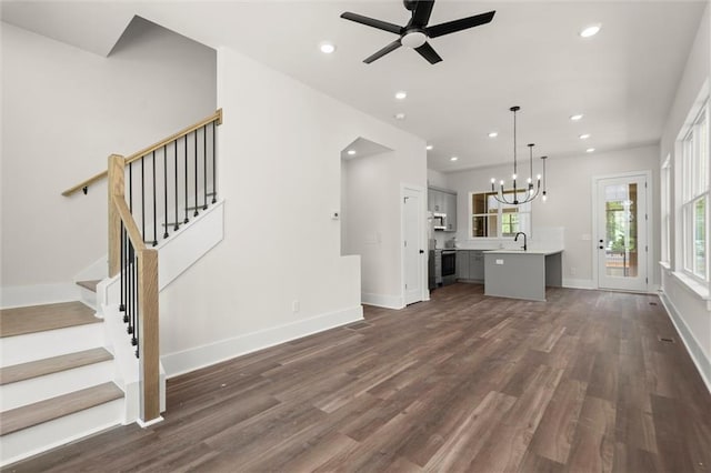 unfurnished living room with recessed lighting, a sink, ceiling fan with notable chandelier, and dark wood-style floors