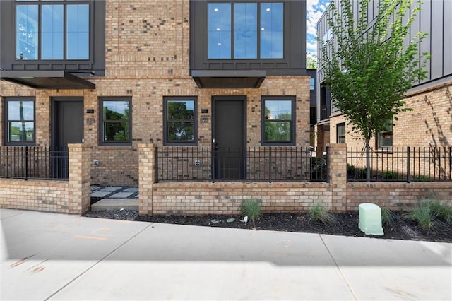 view of front of house featuring brick siding and a fenced front yard