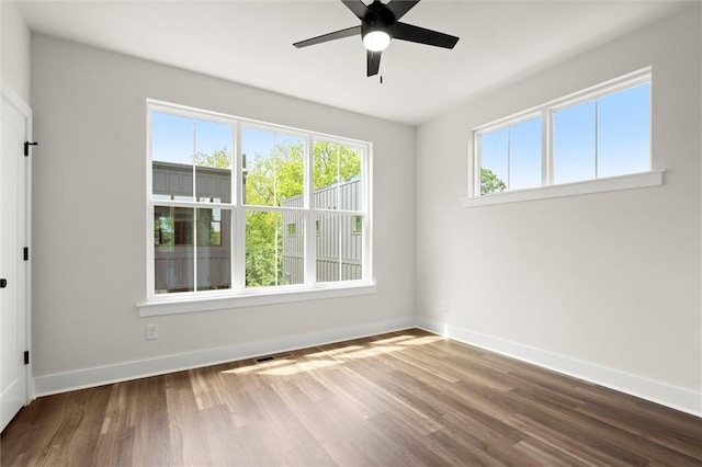 unfurnished room featuring baseboards, ceiling fan, and wood finished floors