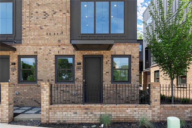 view of front of house with a fenced front yard and brick siding