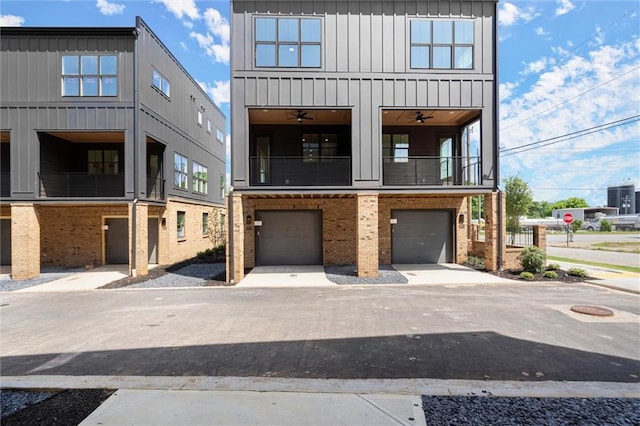view of front facade featuring brick siding, an attached garage, board and batten siding, and a balcony