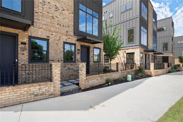 entrance to property featuring board and batten siding and brick siding