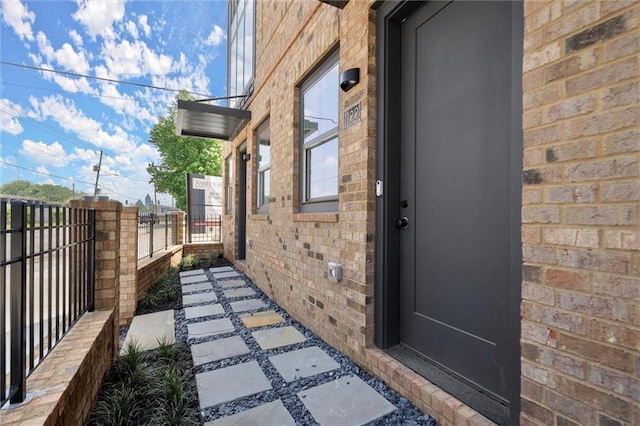 view of side of property with fence and brick siding