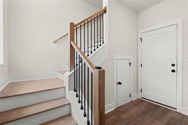 staircase featuring baseboards and wood finished floors