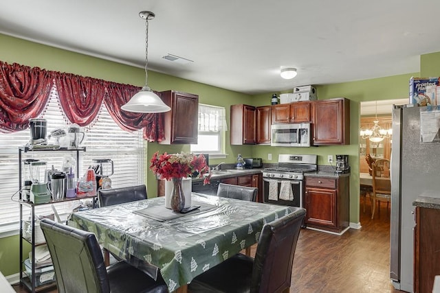 kitchen featuring sink, hanging light fixtures, stainless steel appliances, dark hardwood / wood-style flooring, and a chandelier