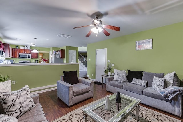 living room featuring ceiling fan and dark hardwood / wood-style flooring