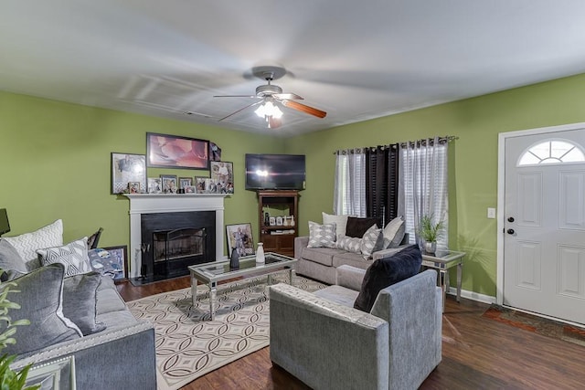 living room featuring dark wood-type flooring and ceiling fan