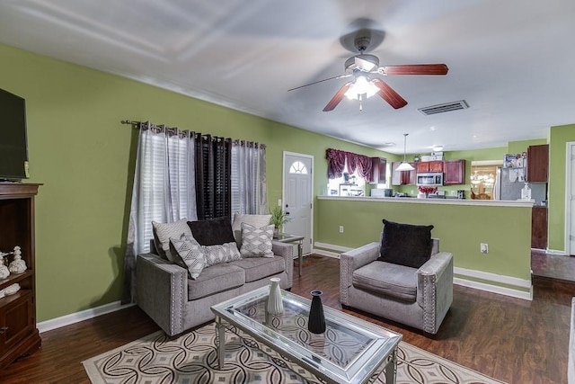 living room featuring a wealth of natural light, dark hardwood / wood-style flooring, and ceiling fan