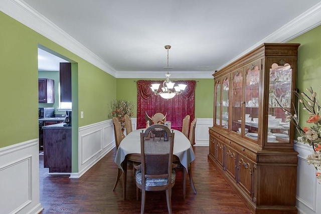 dining space with dark hardwood / wood-style flooring, ornamental molding, and a chandelier