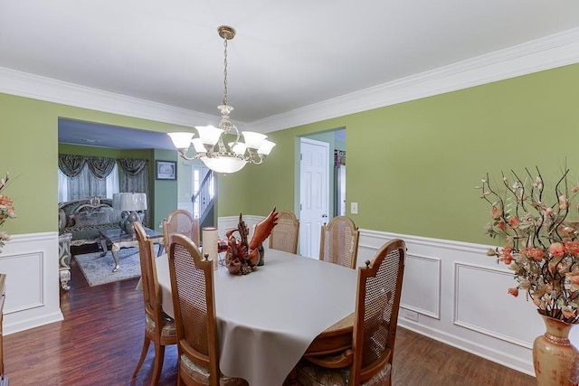 dining space with dark hardwood / wood-style flooring, crown molding, and a notable chandelier