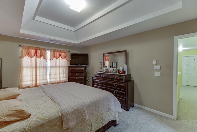 carpeted bedroom featuring a raised ceiling