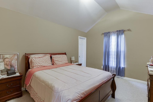 bedroom with lofted ceiling and light colored carpet