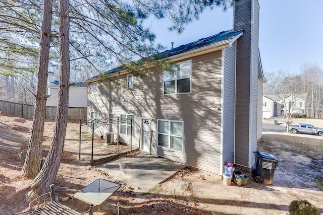 rear view of property with central air condition unit and a patio area