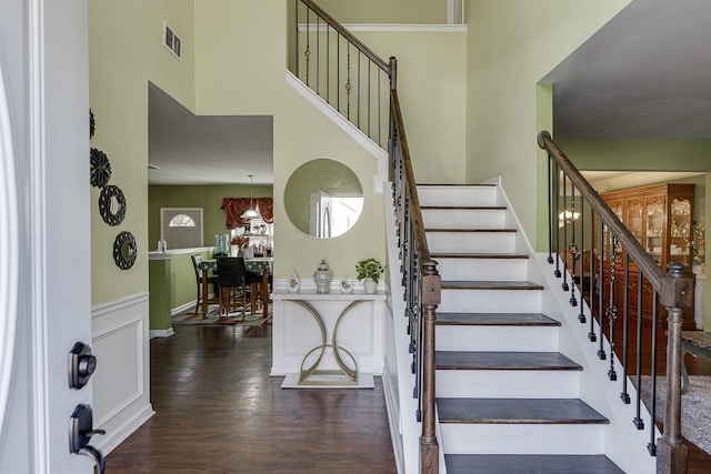 stairs with a chandelier and hardwood / wood-style floors