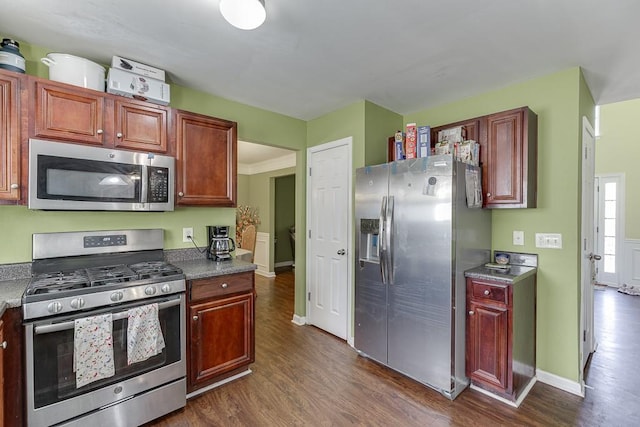 kitchen featuring dark wood-type flooring, appliances with stainless steel finishes, and crown molding