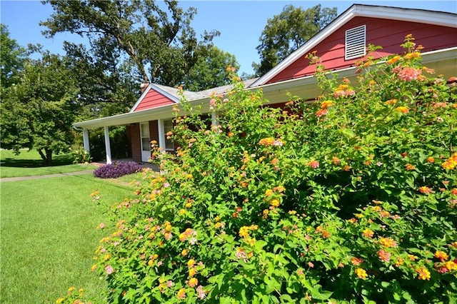 view of property exterior featuring brick siding and a lawn