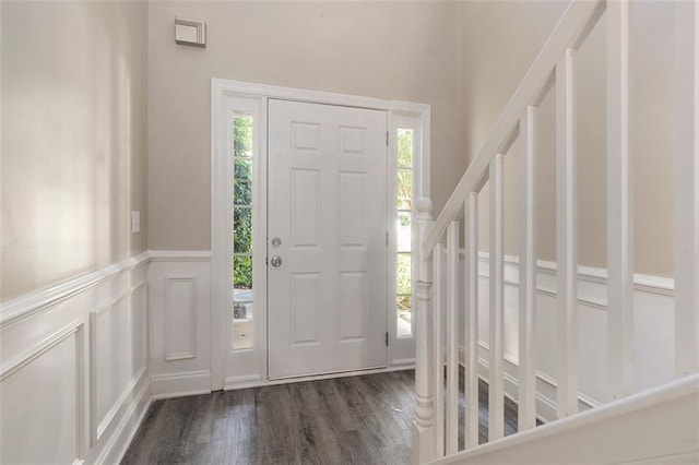 5712 Grande River Rd, Atlanta, GA 30349 - entrance foyer with dark wood-type flooring, a decorative wall, stairs, and a wainscoted wall