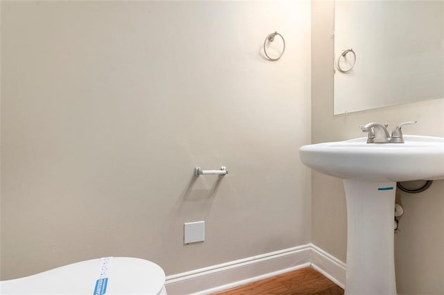 5712 Grande River Rd, Atlanta, GA 30349 - half bathroom with baseboards, wood finished floors, and toilet