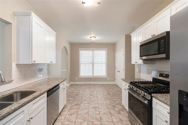 5712 Grande River Rd, Atlanta, GA 30349 - kitchen featuring stainless steel appliances, backsplash, baseboards, and white cabinetry