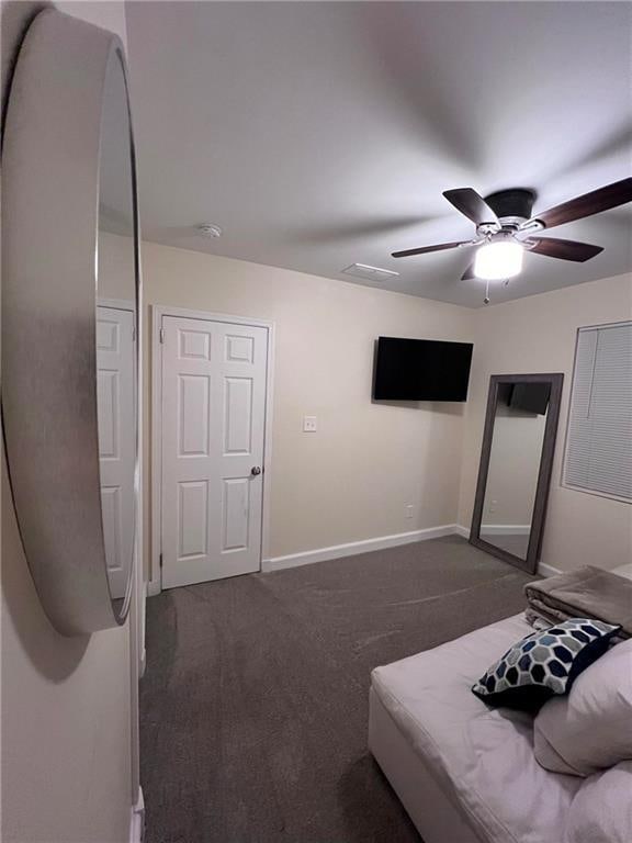 unfurnished bedroom featuring dark colored carpet and ceiling fan