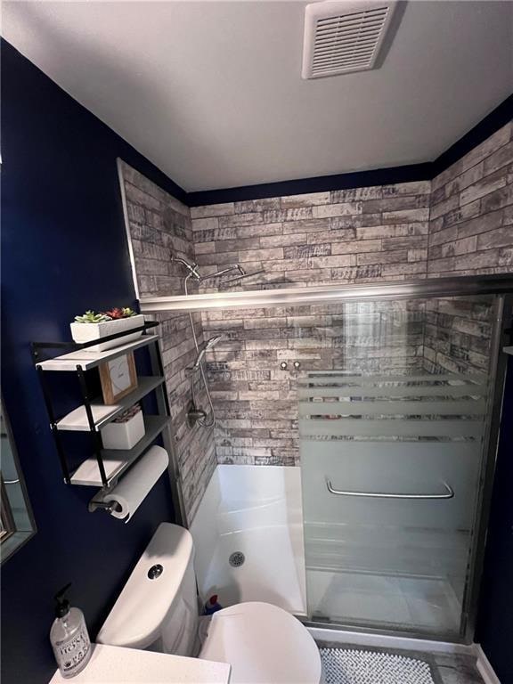 bathroom featuring walk in shower and toilet