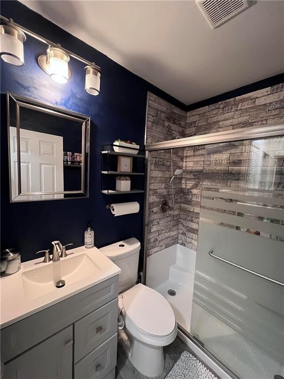 bathroom with vanity, toilet, and a shower with shower door