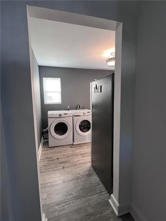 washroom featuring hardwood / wood-style flooring and washer and dryer